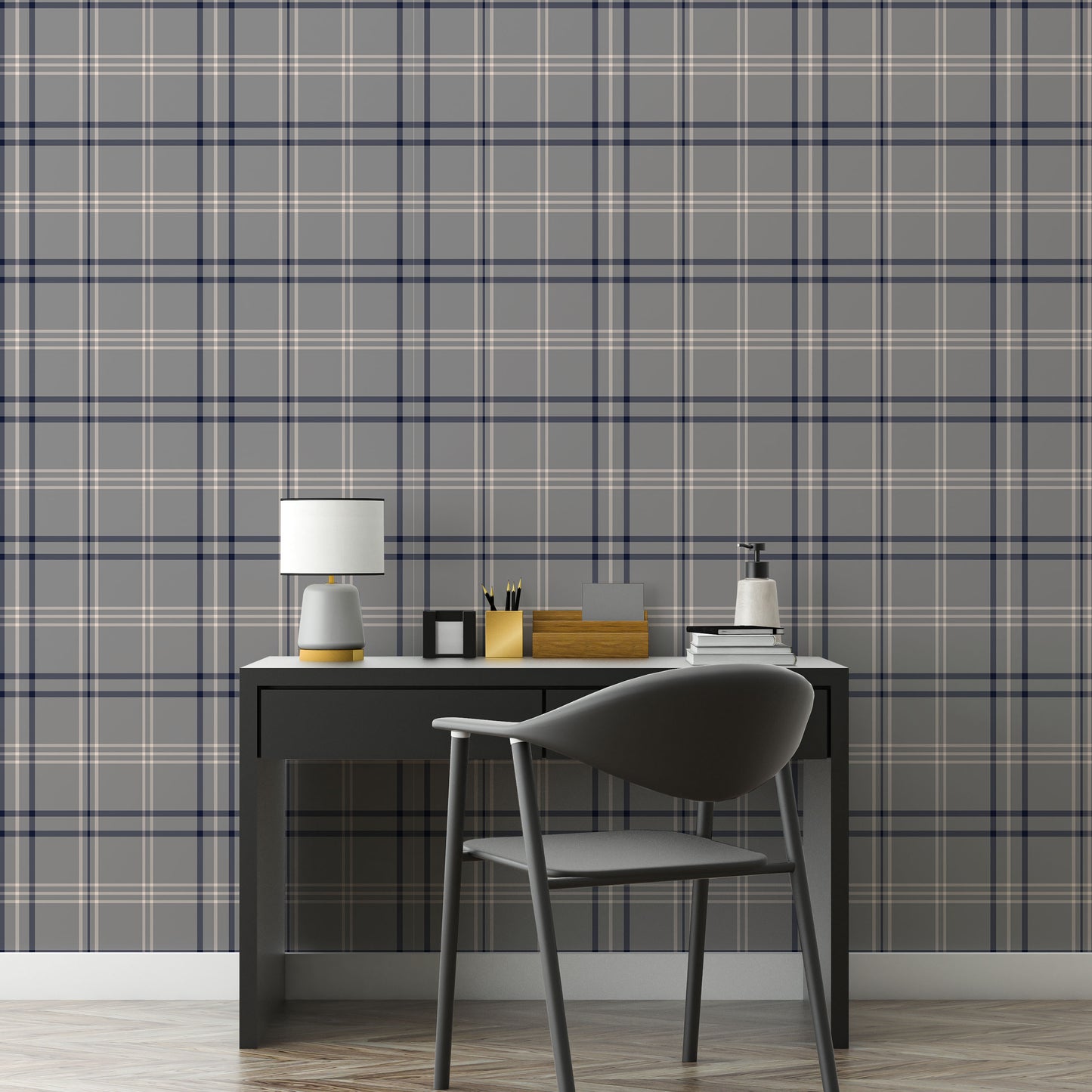 A minimalist home office workspace is set against a wall covered in grey, navy blue, and white plaid wallpaper.
In the center, a sleek black desk features a slim drawer built into its frame. Atop the desk sits a small table lamp with a grey base and a white cylindrical shade, a small square black photo frame, a gold pencil holder filled with pens, a wooden organizer, a stack of books, and a white soap dispenser bottle.A modern dark grey office chair with a curved backrest is pulled up to the desk, angled.