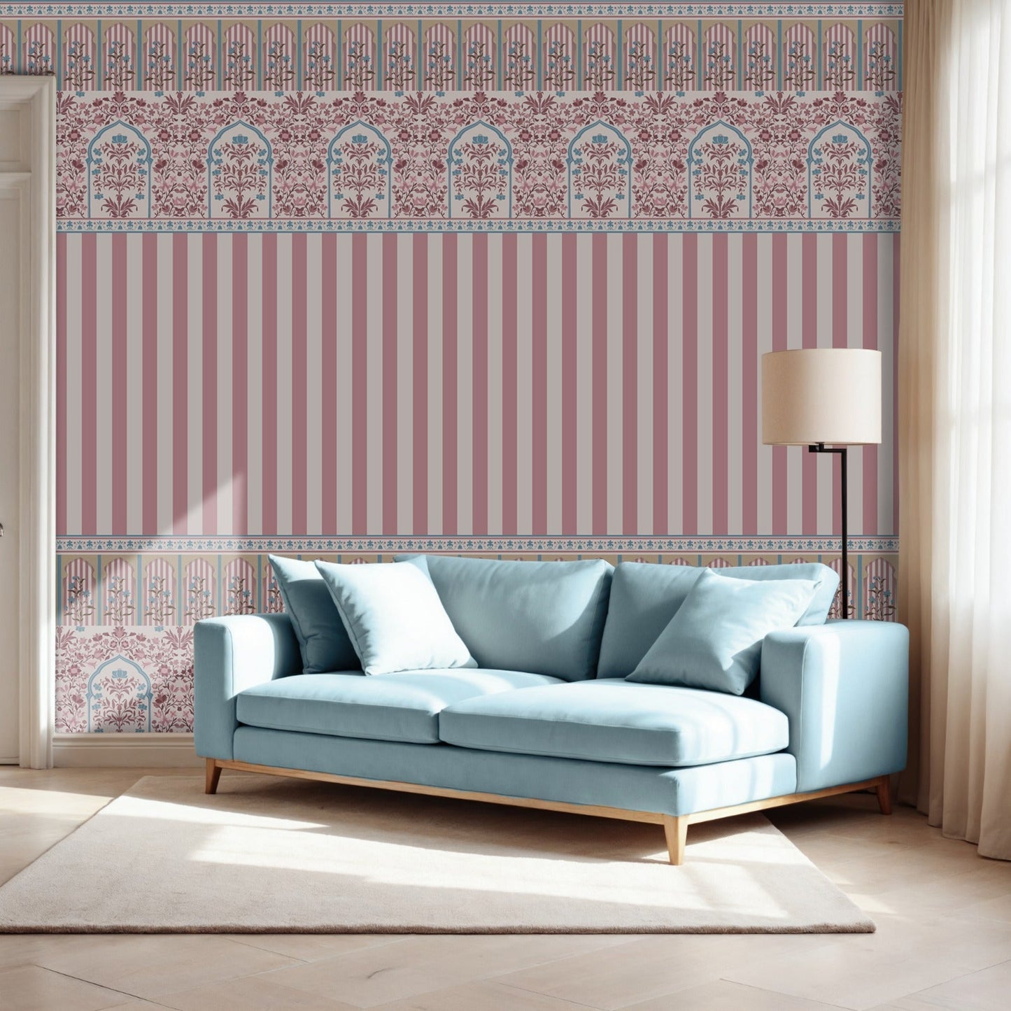 Rajmahal Floral Stripe Wallpaper in dusty rose pink and blue tones, shown behind a modern light blue sofa with a floor lamp and white rug, as seen.