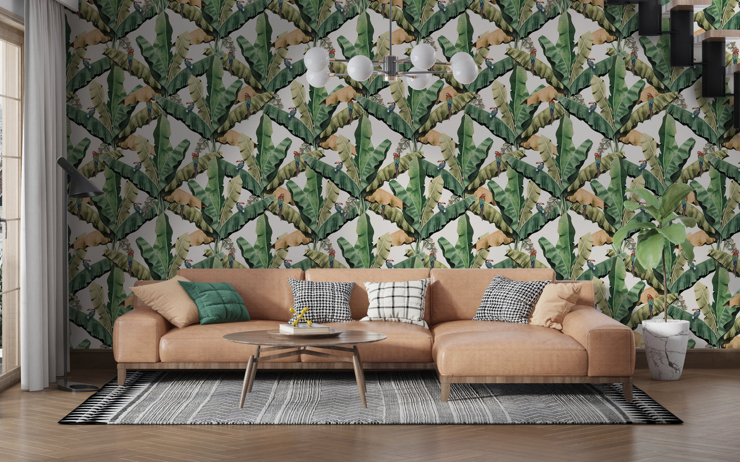 An architectural perspective of a contemporary living room featuring the Banana Leaves Pattern as a full-scale accent wall. The wallpaper’s lush green tones pair strikingly with a cognac leather sectional, geometric patterned rugs, and minimalist lighting, creating a high-energy and stylish tropical atmosphere.