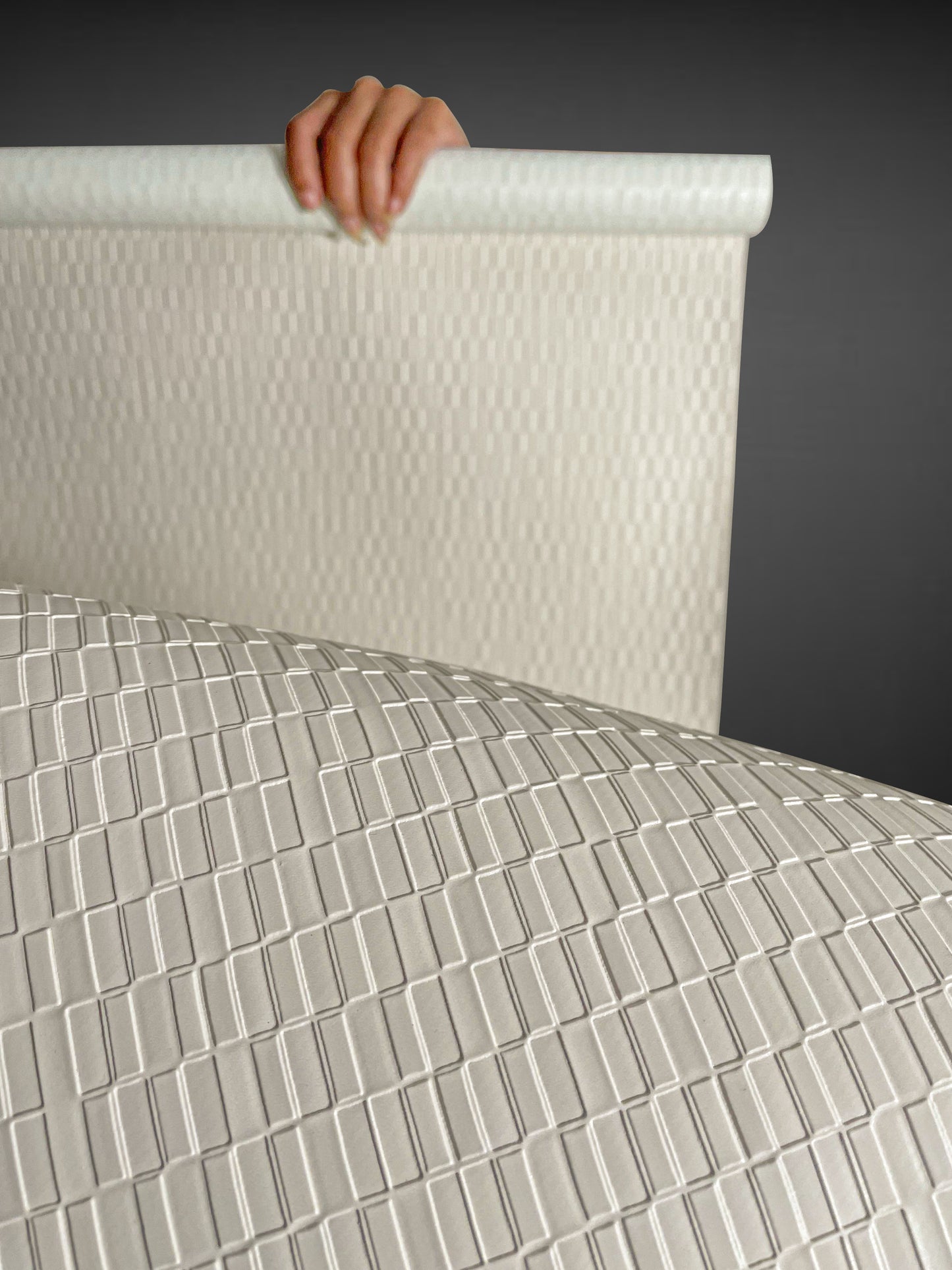 A high-resolution macro detail of Warm Beige Deep Texture Wallcovering, showcasing a high-relief rectangular grid pattern. The image captures the precisely embossed, raised blocks and the subtle, fine-grained texture of the warm beige surface, highlighting its architectural depth and light-reflective qualities.