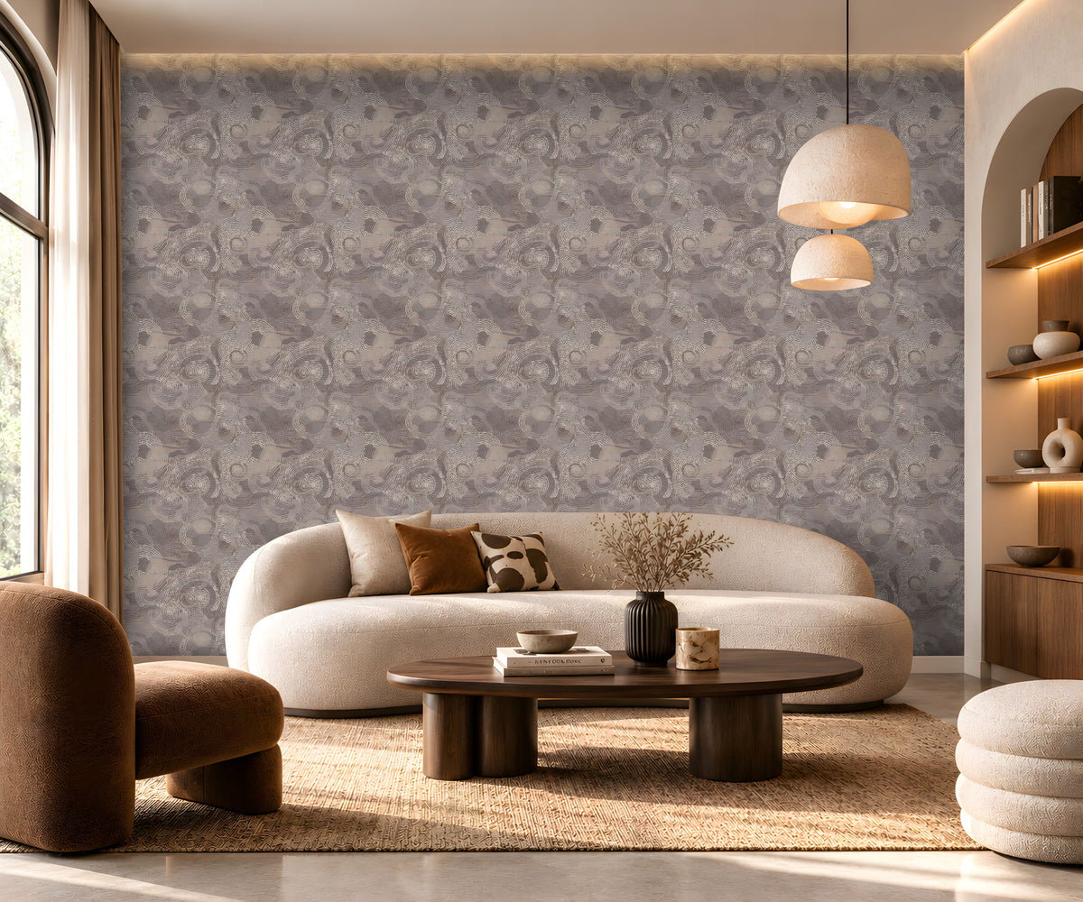 Ethereal Waves Wallpaper in Taupe Grey featuring an intricate flowing wave pattern with soft taupe, warm grey, and subtle beige tones, displayed in a luxurious modern living room with an elegant curved sofa, wooden furniture, warm pendant lighting, and neutral décor.