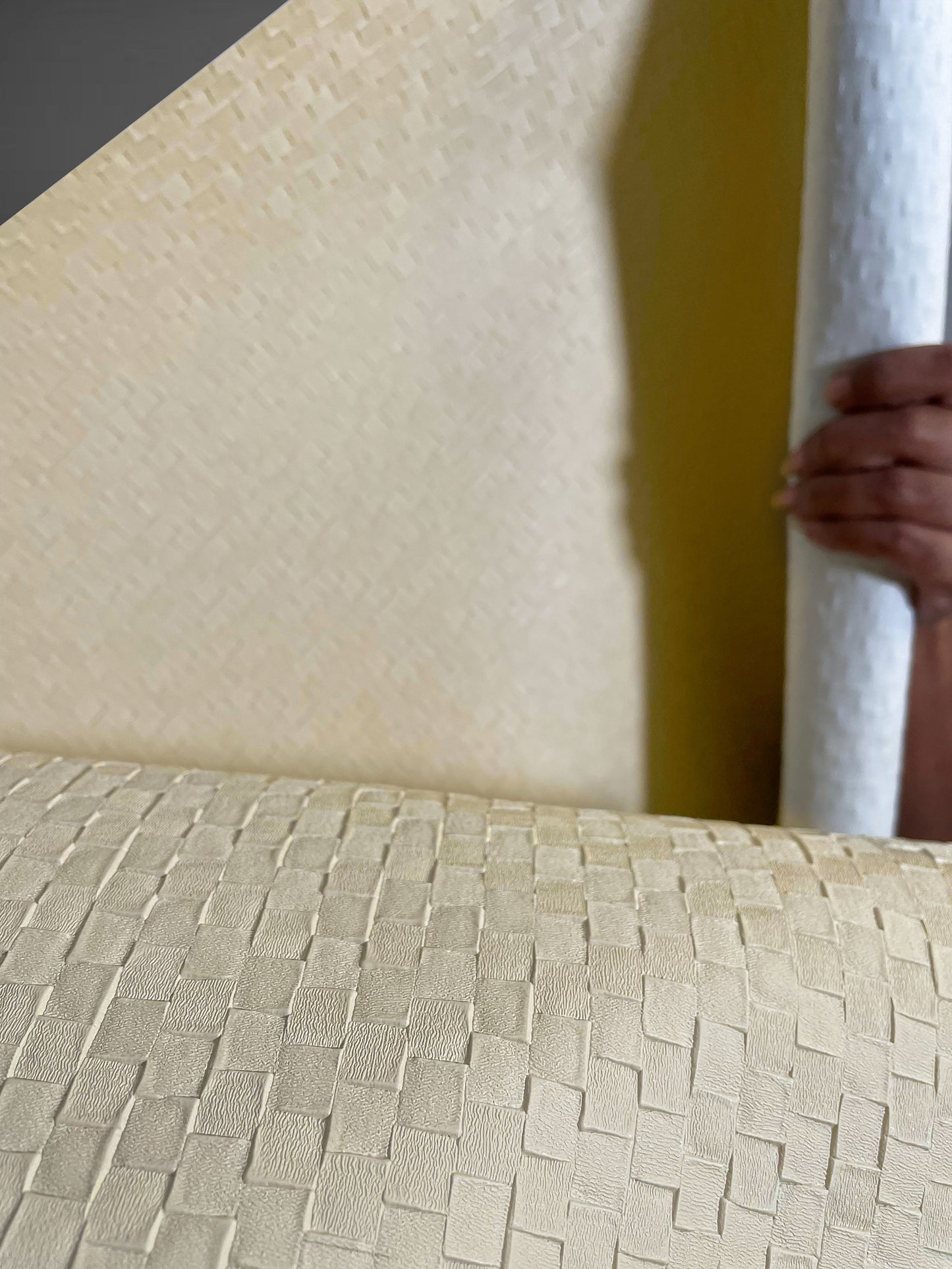 A high-resolution macro detail of Cream Checkered Deep Texture Wallcovering, highlighting the precise raised square grid. The image captures the smooth, creamy-beige finish and the way light defines the sharp edges and recessed borders of the geometric emboss.