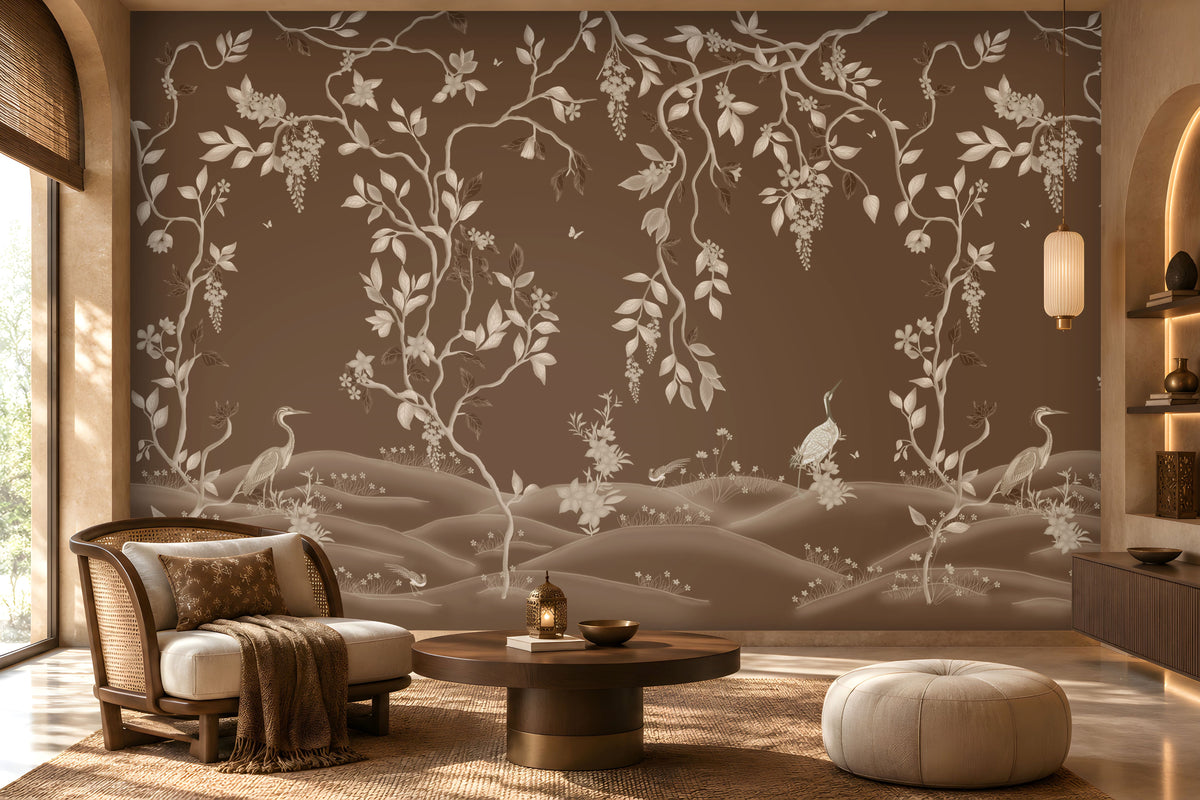 Warm brown botanical wallpaper mural featuring delicate ivory vines, leaves, blossoms, and elegant birds, styled in a luxurious living room with natural wood furniture, a cane accent chair, soft neutral seating, a textured rug, warm ambient lighting, and refined earthy décor.