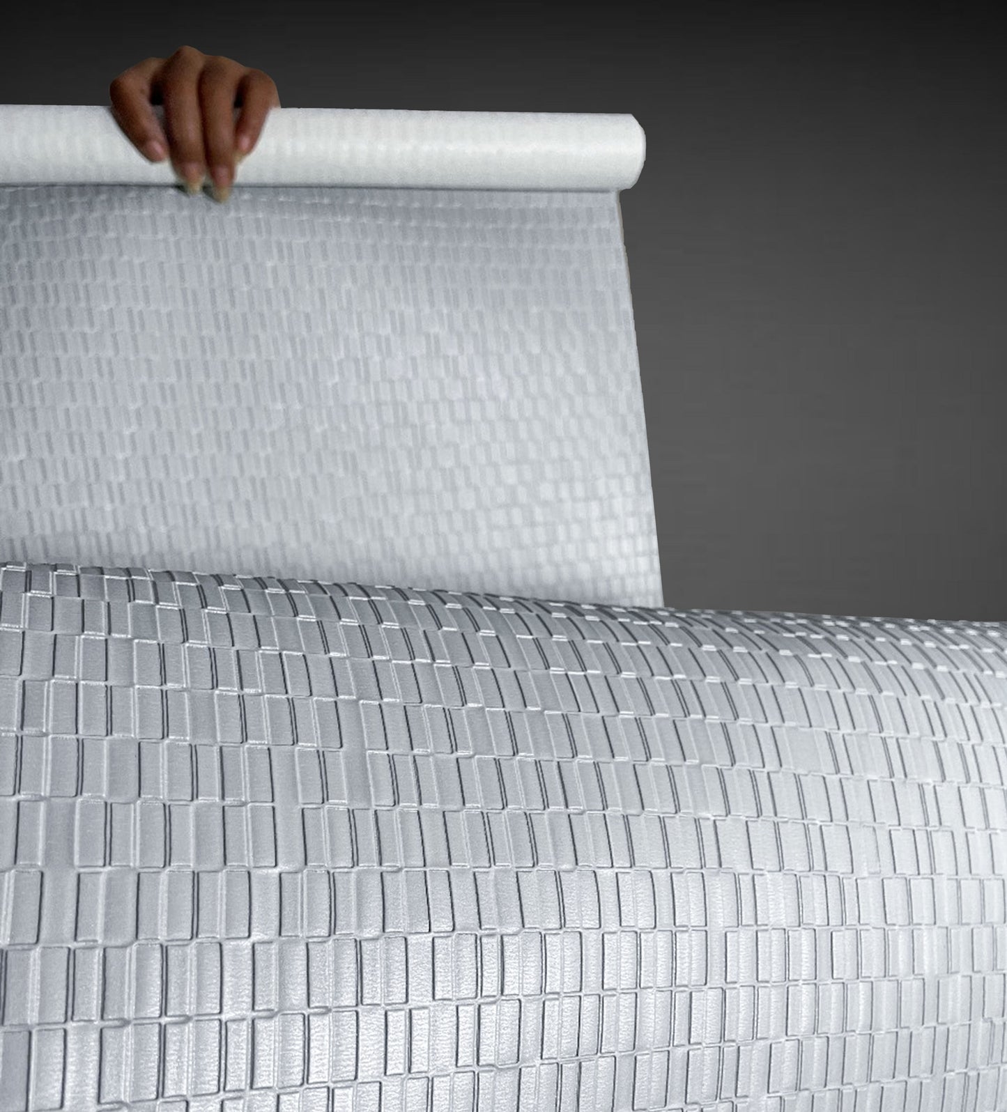 A high-resolution macro detail of Silver Grey Deep Texture Wallcovering, showcasing a high-relief rectangular grid pattern. The image captures the precisely embossed, raised blocks and the subtle, fine-grained texture of the silver-grey surface, highlighting its architectural depth and light-reflective qualities.