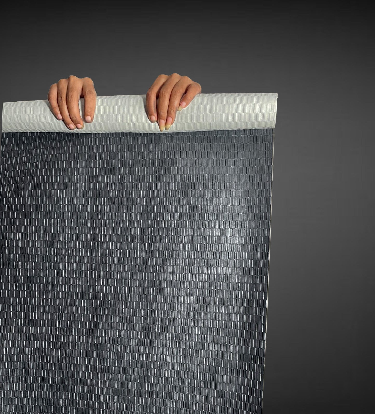 An expansive architectural view of the Charcoal Grey Deep Texture Wallcovering, demonstrating how the rhythmic geometric emboss creates a seamless, structural feature wall. The deep Charcoal Grey palette provides a sophisticated, modern backdrop that adds tactile interest and masks surface irregularities in large-scale commercial spaces.