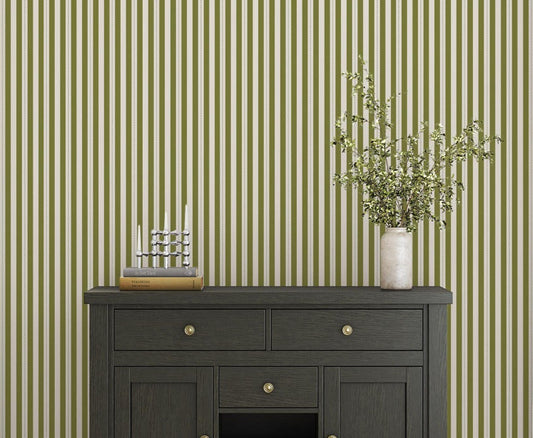 A bright dining area features a soft moss green and white striped wallpaper.
The clean design shows vertical green lines repeating across a textured white base.
In front, a warm wooden table is set with minimalist black chairs.
The sophisticated setup is completed by a contemporary black pendant light hanging above.