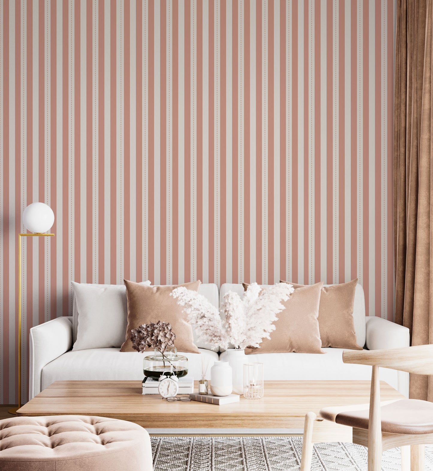 A bright and inviting living space features a warm peach and cream striped wallpaper.
The detailed design shows clean vertical peach bands alongside cream stripes with thin dotted lines.
In front, a plush white sofa is adorned with matching warm tan accent pillows.
The cozy room setup is beautifully completed with a light wood coffee table and a gold floor lamp.