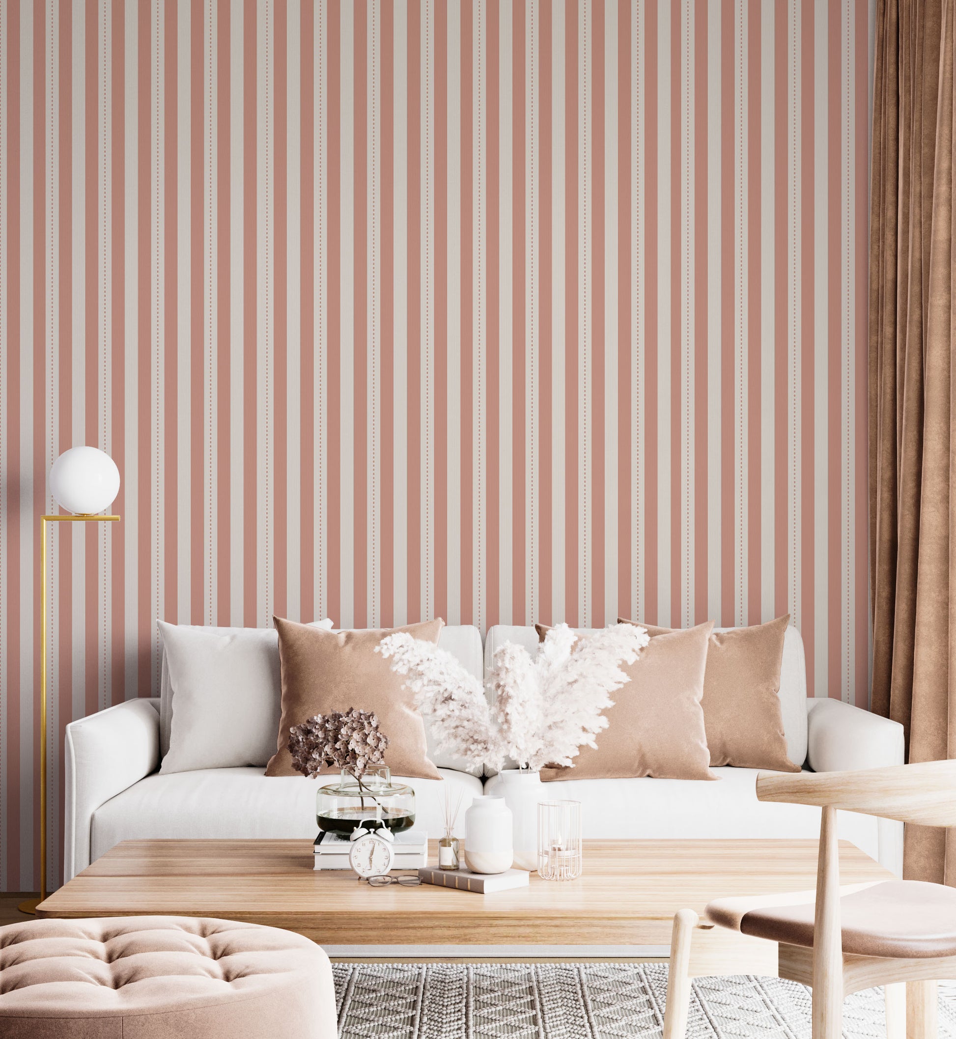 A bright and inviting living space features a warm peach and cream striped wallpaper.
The detailed design shows clean vertical peach bands alongside cream stripes with thin dotted lines.
In front, a plush white sofa is adorned with matching warm tan accent pillows.
The cozy room setup is beautifully completed with a light wood coffee table and a gold floor lamp.