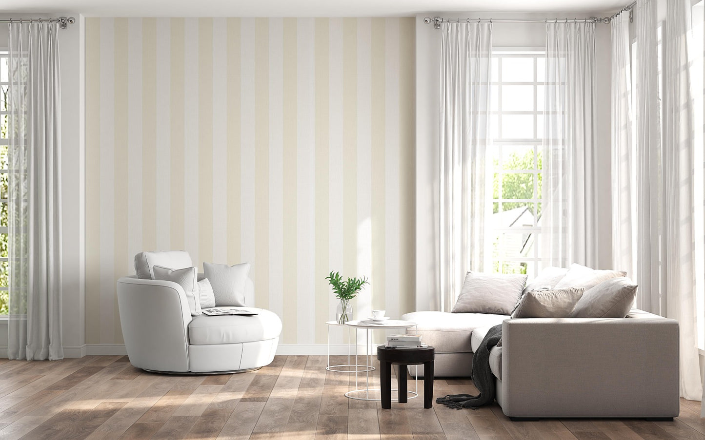 A sunlit living room features a striped wallpaper pattern.
The wallpaper colors are a pale cream beige and crisp white.
The design has wide, evenly spaced vertical stripes across the wall.
A large, rounded white armchair sits on the left side.
A light grey sectional sofa with pillows rests on the right.
The room is complete with natural wood flooring and white curtains.