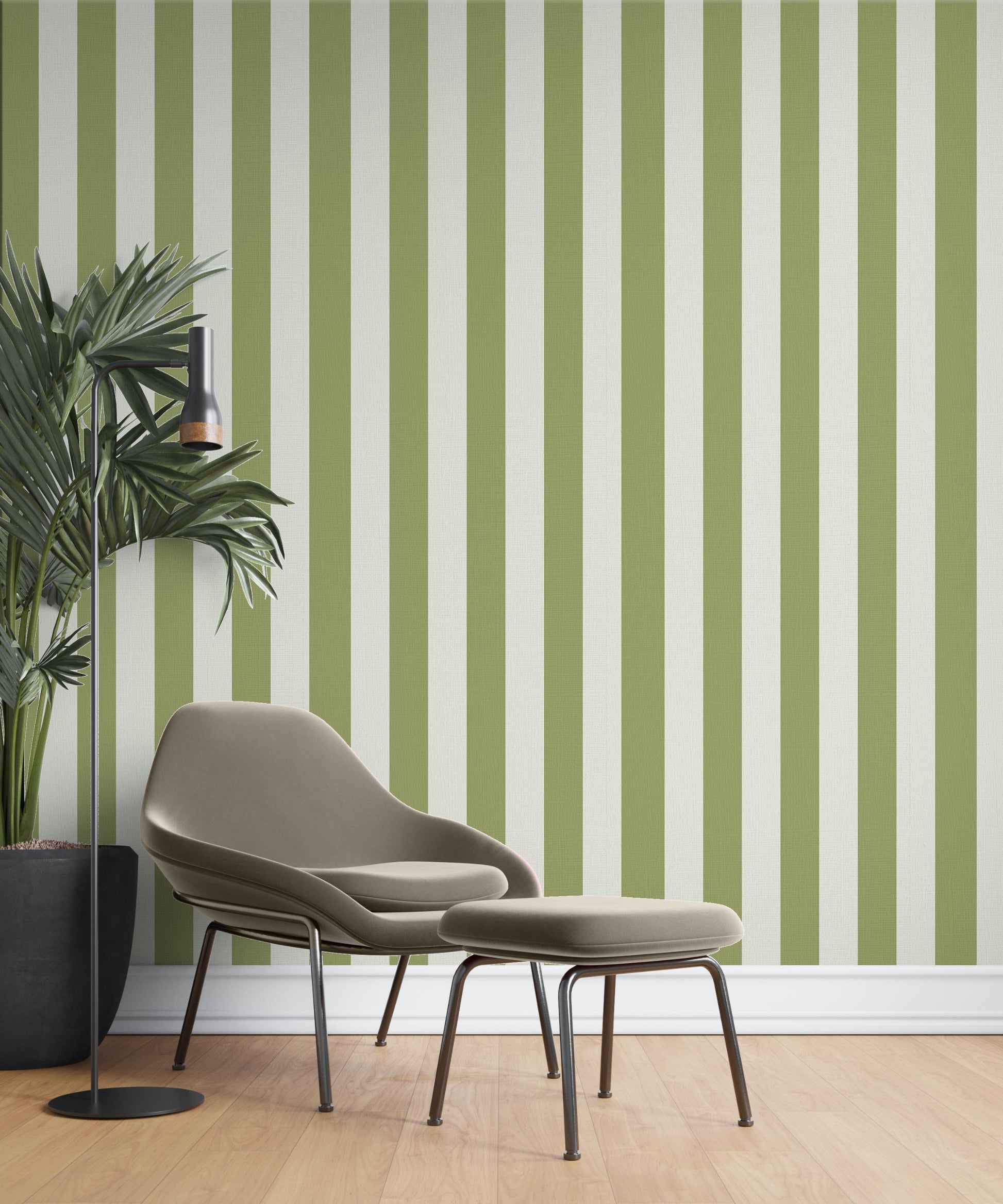 A cozy reading corner features a striped wallpaper pattern.
The wallpaper colors are an olive green and crisp white.
The design has clean, evenly spaced vertical stripes across the wall.
A modern taupe armchair sits in the center with a matching ottoman.
A tall black floor lamp stands next to a large potted plant.
The look is finished with light wood flooring and a white baseboard.