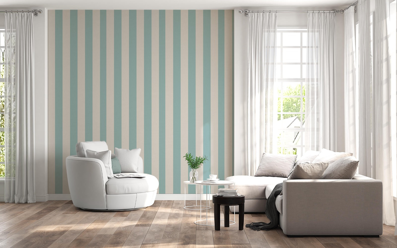 A sunlit living room features a soft sage blue and warm cream striped wallpaper.
The design showcases clean, evenly spaced vertical stripes filling the central accent wall.
In front, a rounded white armchair and a light grey sectional sofa face each other.
The bright, modern space is complete with natural wood flooring and sheer white curtains.