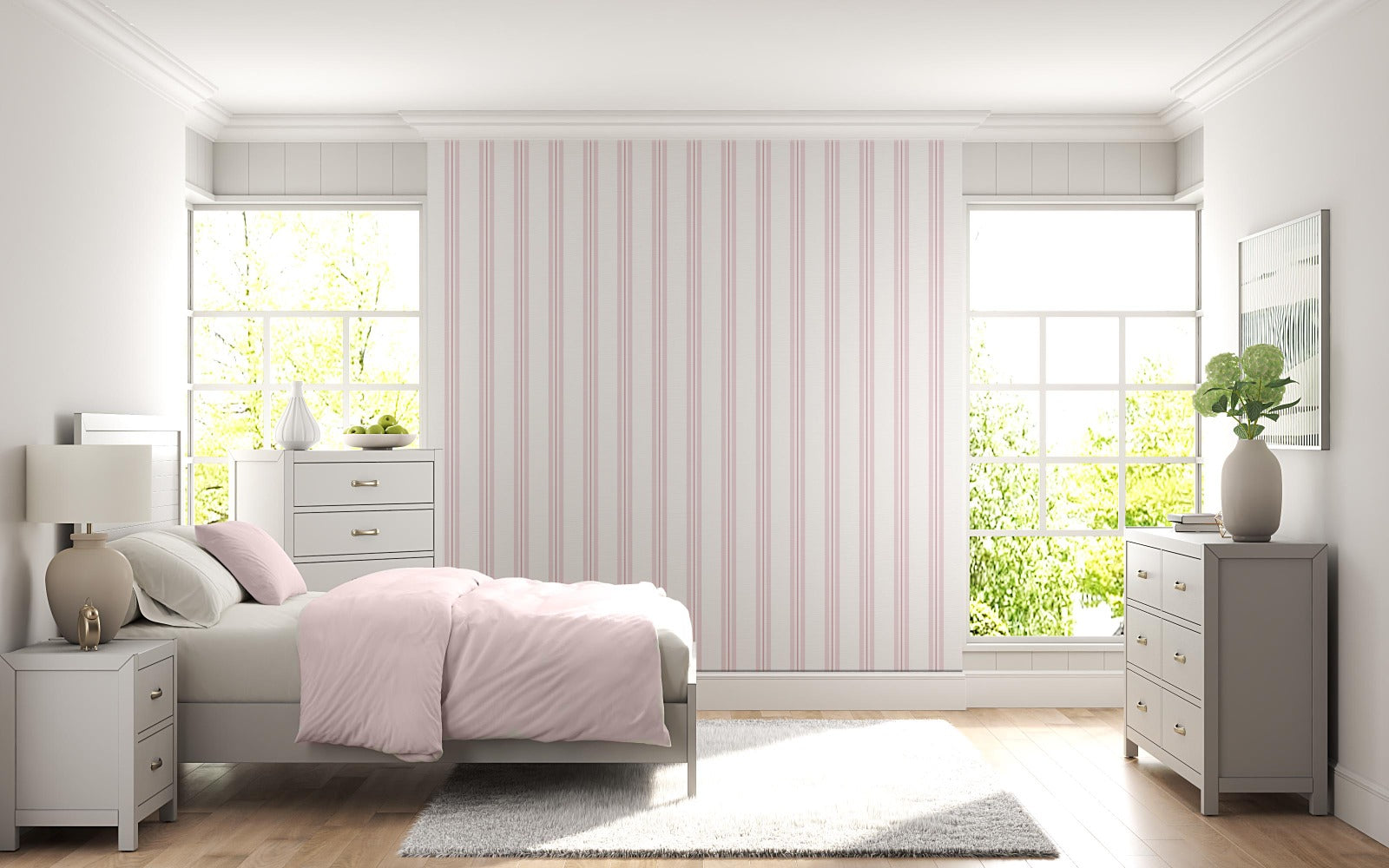 A bright bedroom features a soft pink and white vertically striped wallpaper.
The detailed design shows thin, evenly spaced pink stripes running down a white base.
In front, a neatly made bed with a light pink comforter rests near a matching nightstand.
The relaxing space is complete with two light grey dressers, large windows, and a rug.