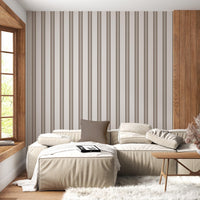 A bright, modern entryway features a soft sage green and white striped wallpaper.
The clean design shows vertical green stripes repeating across a lightly textured white base.
In front, a sleek black console table stands under a round mirror on the wall.
The organized space is neatly completed with a matching black stool and a simple glass vase.