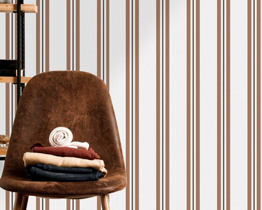 A warm dining area features a soft brown and white striped wallpaper.
The clean design shows vertical light brown lines repeating across a cream base.
In front, a sleek dark wooden table is paired with minimalist black chairs.
The sophisticated setup is completed by a contemporary black pendant light hanging above.
