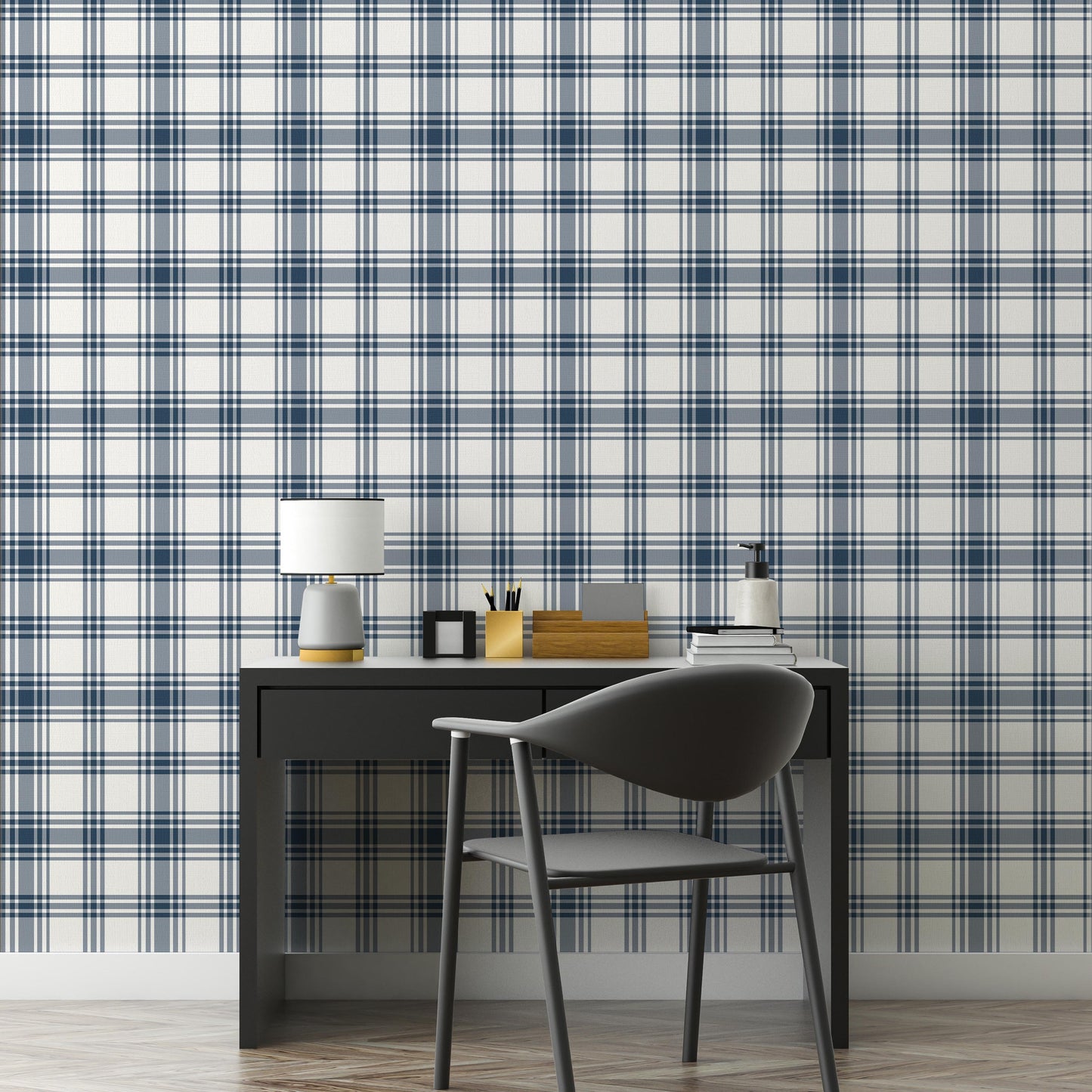 A clean workspace setup features a classic navy blue and white plaid wallpaper.
The detailed design shows intersecting dark blue stripes forming grids on a white base.
In front, a sleek dark grey desk holds a small lamp, notebooks, and office accessories.
A modern dark grey desk chair with a rounded back completes the organized study area.