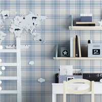 A charming children's study area features a soft pastel blue and white plaid wallpaper.
The detailed design shows intersecting light blue stripes forming grids on a white base.
In front, a small white desk setup with a wooden chair sits centered against the wall.
The playful space is complete with floating shelves, a toy wagon, and a decorative ladder.