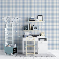 A charming children's study area features a soft pastel blue and white plaid wallpaper.
The detailed design shows intersecting light blue stripes forming grids on a white base.
In front, a small white desk setup with a wooden chair sits centered against the wall.
The playful space is complete with floating shelves, a toy wagon, and a decorative ladder.