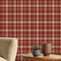 A close-up view displays wallpaper with a warm red background.
The design features a classic, tight plaid and tartan pattern.
It includes a mix of thick beige stripes that form large blocks.
Fine white lines crisscross over the grid, adding detailed accents.
The colors combine deep red, soft tan beige, and crisp white lines.
The overall pattern has a textured fabric appearance in a traditional style.