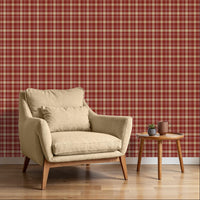 A close-up view displays wallpaper with a warm red background.
The design features a classic, tight plaid and tartan pattern.
It includes a mix of thick beige stripes that form large blocks.
Fine white lines crisscross over the grid, adding detailed accents.
The colors combine deep red, soft tan beige, and crisp white lines.
The overall pattern has a textured fabric appearance in a traditional style.