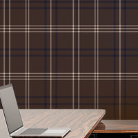 A bright, modern office features a desk setup with a brown plaid accent wall.
A glossy, dark wood desk holds an open laptop on its shiny surface.
Behind the desk, a matching storage cabinet holds a row of grey binders.
A high-backed office chair with a rich wood grain back faces the desk.
Light pours in from a large window on the right side of the room.
The room is complete with light-colored wood flooring and clean white walls.