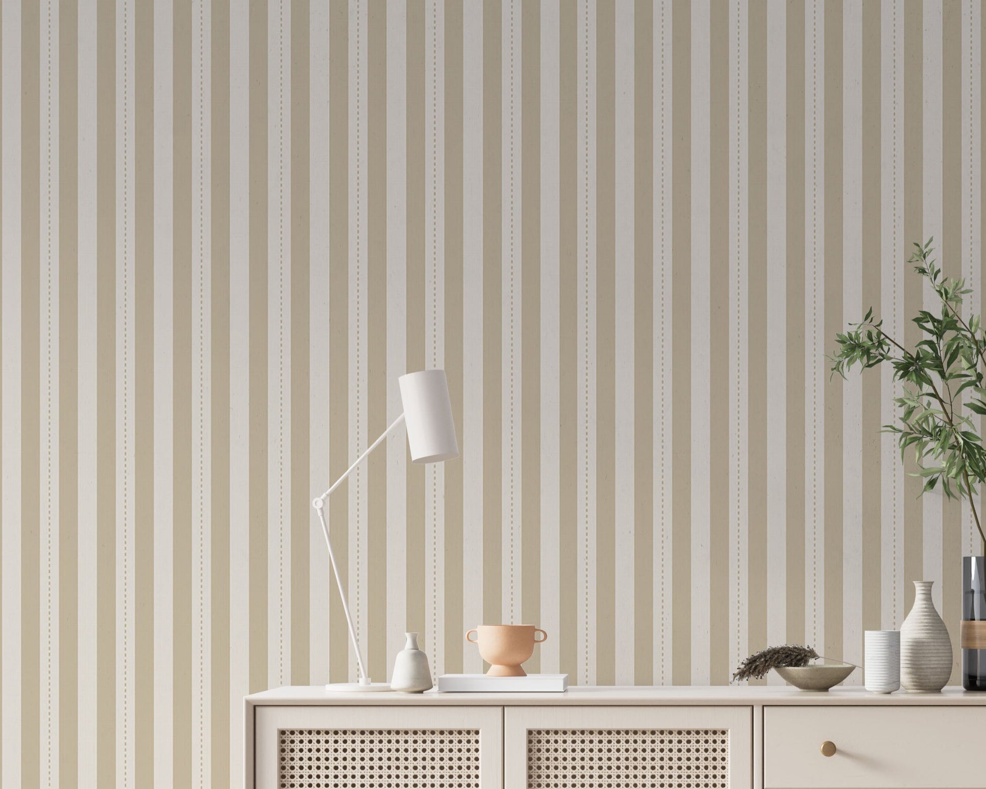A minimalist hallway setup features a pale sand and cream striped wallpaper.
The detailed design shows clean vertical tan bands alongside cream stripes with thin dotted lines.
In front, a cream console cabinet with woven mesh doors stands against the wall.
The bright, neutral space is elegantly finished with a modern desk lamp and a leafy plant.