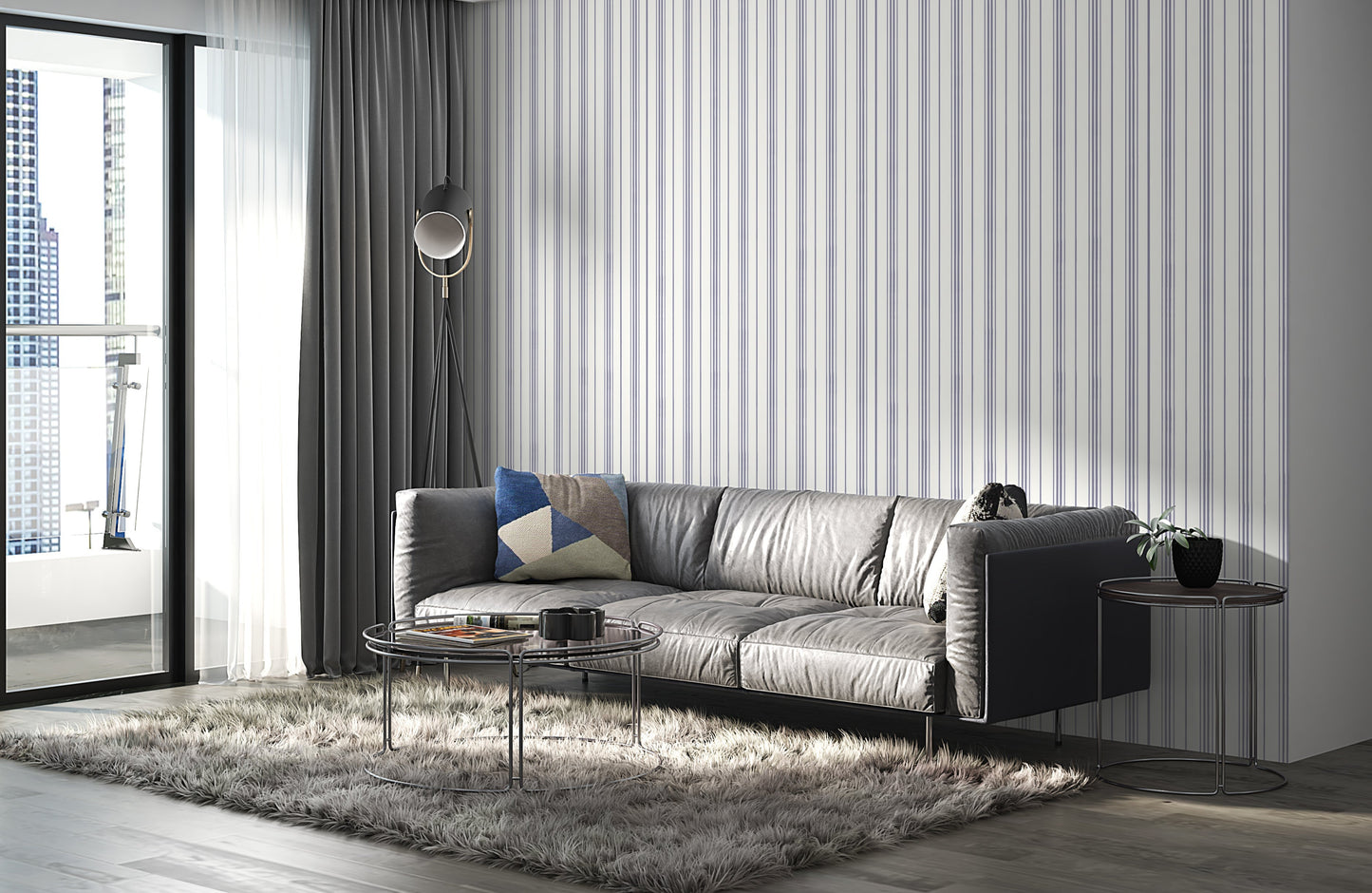 A gray leather sofa with a geometric-patterned throw pillow sits against a white wall decorated with thin vertical lavender-gray stripes. The minimalist interior features soft textures and a modern, neutral-toned design.