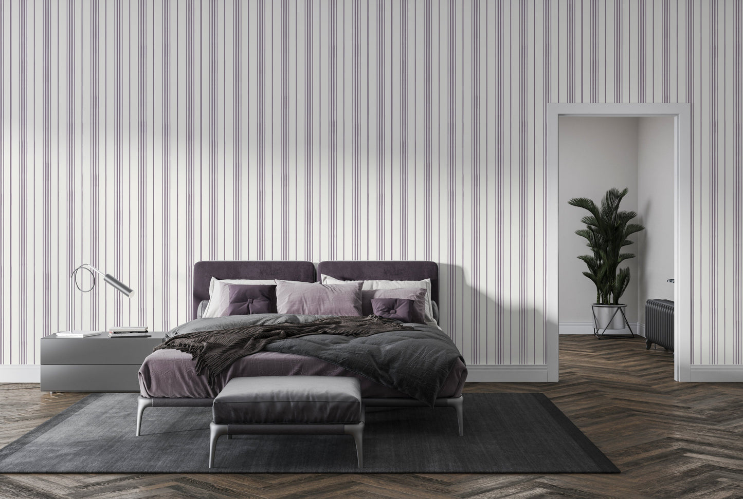 A modern bedroom setting featuring a bed with a deep purple tufted headboard against a white wall with vertical lavender and grey stripes. The bed is neatly styled with grey bedding, a textured dark brown throw blanket, and a mix of lavender and deep purple pillows. To the left, a sleek, minimalist silver desk lamp with a curved arm sits on a dark grey bedside table next to a small stack of books.