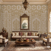 Elegant living room inspired by traditional Indian palace architecture, featuring carved dark-wood seating with cream upholstery arranged around a wooden coffee table. The walls are covered in intricate white-and-gold floral and geometric patterns, complemented by an ornate framed mirror and a hanging lantern. Arched doorways and large scalloped windows overlook a lakeside palace and distant hills. Decorative brass vessels, patterned cushions, and a richly detailed area rug add warmth and luxury to the spac