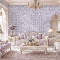 Elegant, light-filled living room inspired by Indian palace architecture, featuring carved white archways, crystal chandeliers, and lavender-patterned wallpaper with floral and peacock motifs. Ornate whitewashed furniture with lavender cushions surrounds a carved coffee table on a pale patterned rug. Large arched openings reveal a sunlit terrace and garden, while floral arrangements, decorative lanterns, and potted palms enhance the soft, luxurious atmosphere.