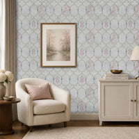 Pichwai Vrinda Jaal White wallpaper featuring an intricate floral trellis pattern with delicate pink and blue Pichwai-inspired motifs, styled in an elegant living room with a cream armchair, framed artwork, and classic décor.