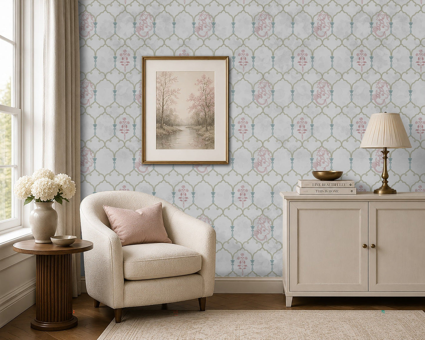 Pichwai Vrinda Jaal White wallpaper featuring an intricate floral trellis pattern with delicate pink and blue Pichwai-inspired motifs, styled in an elegant living room with a cream armchair, framed artwork, and classic décor.