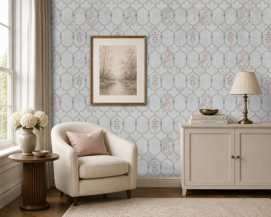 Pichwai Vrinda Jaal White wallpaper featuring an intricate floral trellis pattern with delicate pink and blue Pichwai-inspired motifs, styled in an elegant living room with a cream armchair, framed artwork, and classic décor.