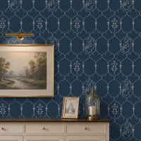 **Alt Text:**
Deep heritage blue wallpaper featuring an intricate Pichwai-inspired trellis pattern with delicate floral motifs and traditional cow illustrations, styled behind a cream sideboard with framed landscape art and brass décor accents in an elegant living room.
