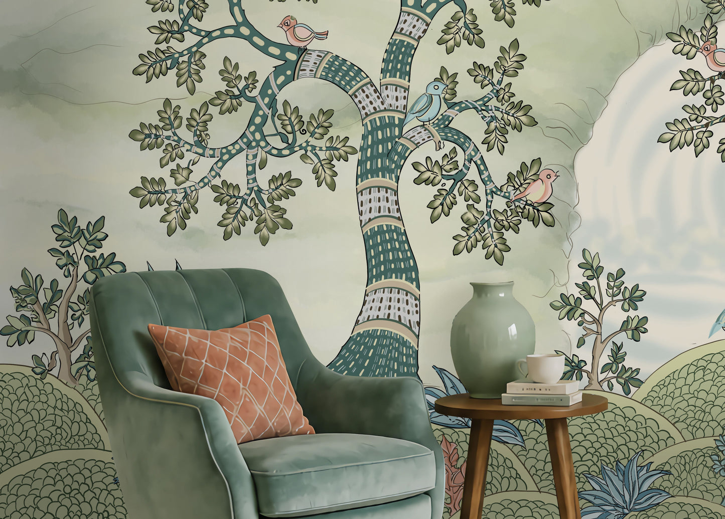 Pastel woodland wall mural featuring hand-painted sage green trees, birds in flight, and deer in a serene forest landscape, styled in a cozy living room with a green armchair and wooden console table.