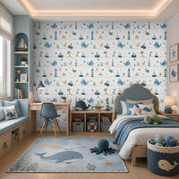 Little Mariners – Ocean Blue kids wallpaper featuring playful whales, sailboats, lighthouses, turtles, and sea creatures in soft blue tones, styled in a nautical-themed children's bedroom with ocean-inspired décor and plush toys.