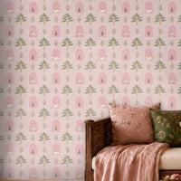 Blush pink Indian heritage wallpaper with floral, tree, arch and cow motifs, creating a charming accent wall in a cozy living room with wooden seating and pink cushions.