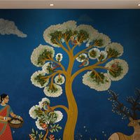 Traditional Gond Art wallpaper in royal blue featuring hand-painted Indian folk art with trees, birds, wildlife, and village life, displayed as a luxury living room feature wall.