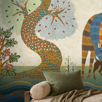 Traditional Gond Art wallpaper mural featuring hand-painted Indian folk art with colorful trees, birds, deer, cattle, and a village woman on a soft ivory background, showcased in a warm contemporary living room with natural wood furniture and earthy décor.