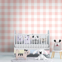 A charming room features a soft pastel checks wallpaper in a peach theme.
The delicate design displays a clean grid pattern with intersecting pink and cream lines.
In front, a small wooden table holds a white vase with small pink flowers.
The sweet, bright interior space creates a warm, simple, and comforting atmosphere.