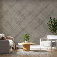 A structured interior setting features a striped wallpaper in a bold Mossbury style.
The clean textured design displays alternating vertical bands of golden yellow, soft cream, and muted grey.
In front, a minimalist credenza cabinet with white, light grey, and teal drawers is centered nicely.
The neat interior space is beautifully completed by a white wavy ceramic vase holding a small leafy plant.