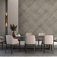 A bright living room features a textured crosshatch wallpaper in a mouse grey theme.
The fabric-look pattern displays intersecting dark charcoal sketch lines over a warm beige background.
In front, a comfortable cream sofa sits near a matching modern white accent chair.
The contemporary interior setup is completed by a small wooden coffee table holding a green plant.