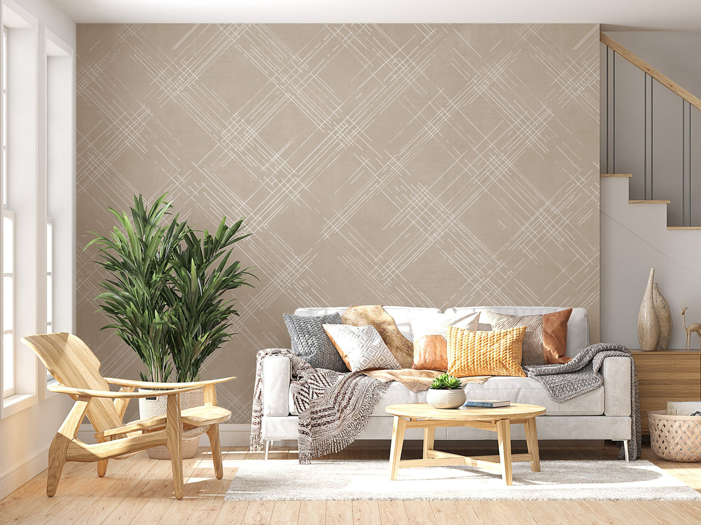 A bright living room features a textured crosshatch wallpaper in a warm beige theme.
The fabric-look pattern displays intersecting white sketch lines angled dynamically over a sandy beige backdrop.
In front, a cozy white sofa with colourful textured pillows sits next to a light wood lounge chair.
The sunny, welcoming interior space is beautifully completed by a tall, leafy green potted plant.