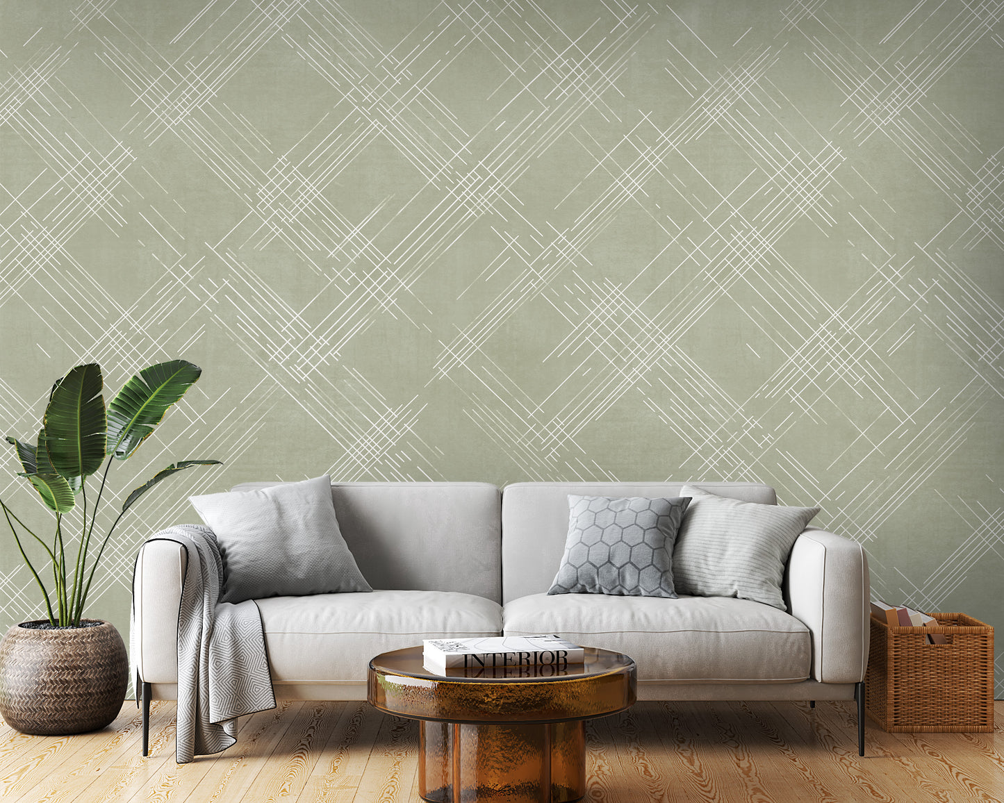 A contemporary living room features a textured crosshatch wallpaper in an olive grey theme.
The fabric-look pattern displays intersecting white sketch lines layered across a muted olive green backdrop.
In front, a comfortable white sofa with grey throw pillows sits behind a round amber glass coffee table.
The calm and stylish interior space is completed by a large leafy green potted plant on the left.