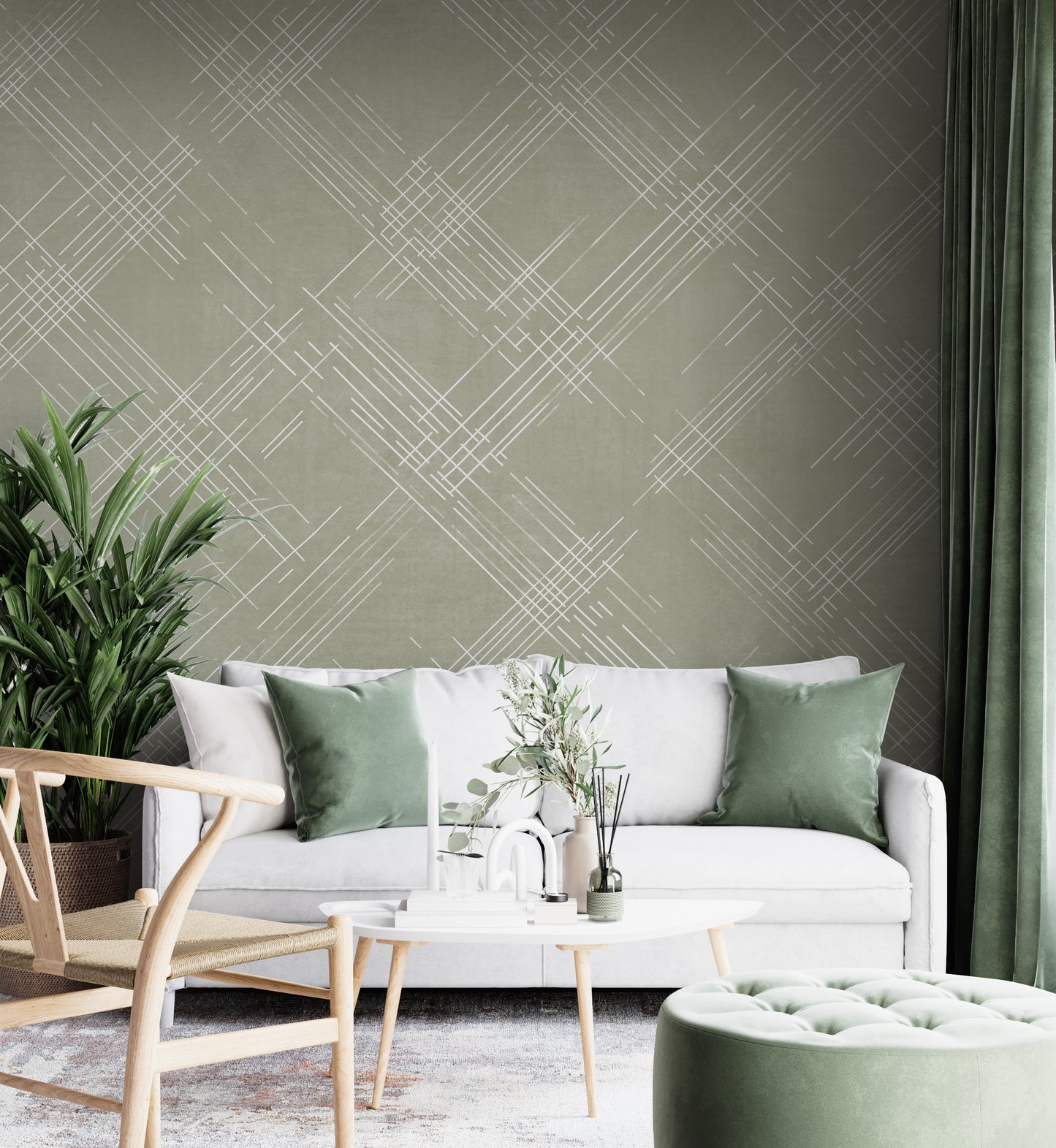 A contemporary living room features a textured crosshatch wallpaper in an olive grey theme.
The fabric-look pattern displays intersecting white sketch lines layered across a muted olive green backdrop.
In front, a comfortable white sofa with grey throw pillows sits behind a round amber glass coffee table.
The calm and stylish interior space is completed by a large leafy green potted plant on the left.