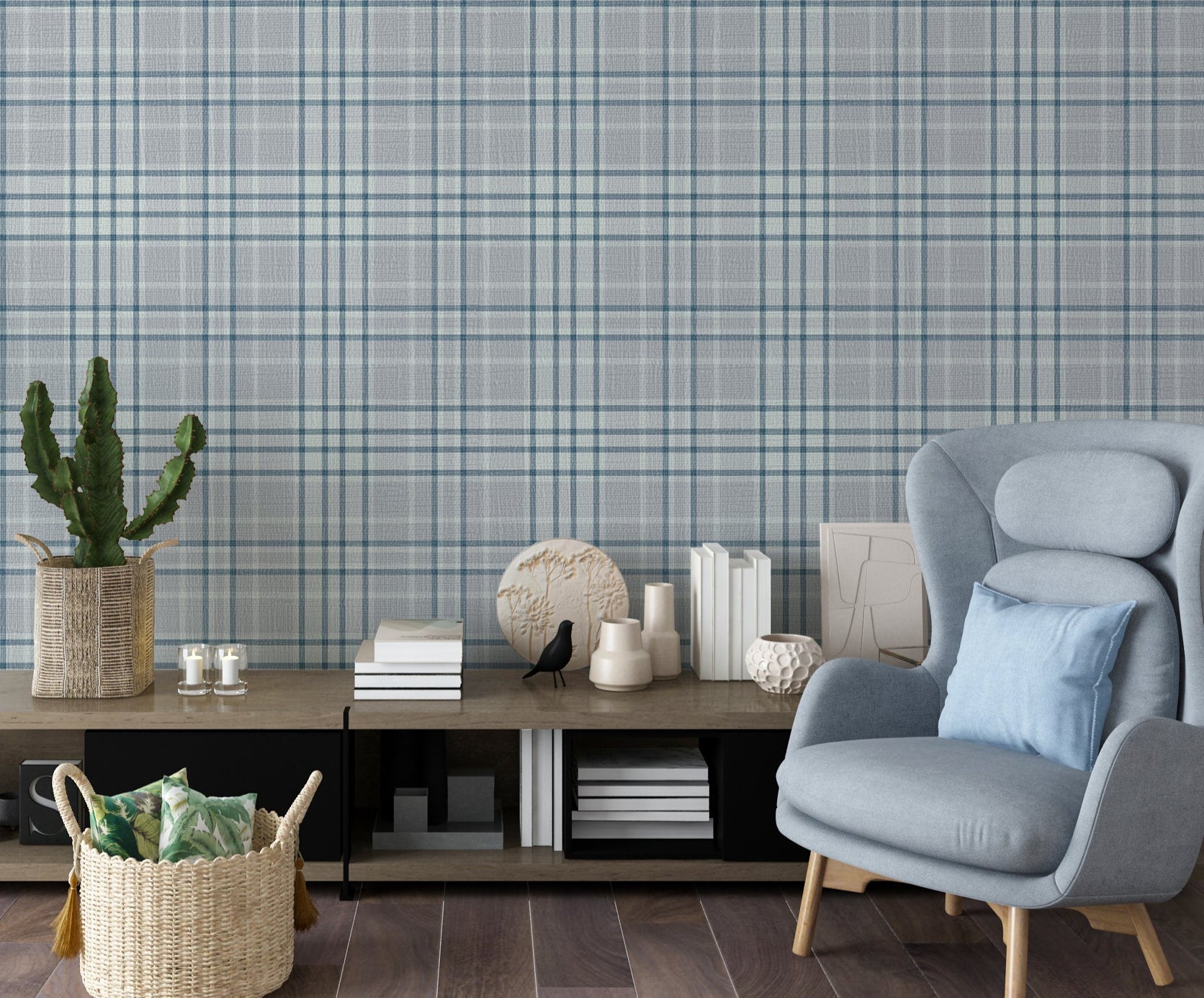 A modern living room features a textured plaid wallpaper in soft lavender grey tones.
The fabric-look pattern displays an intricate grid with intersecting blue-grey and white lines.
In front, a comfortable light blue wingback chair with a matching pillow sits to the right.
The cozy interior space is completed by a low wooden console table holding books and decor.