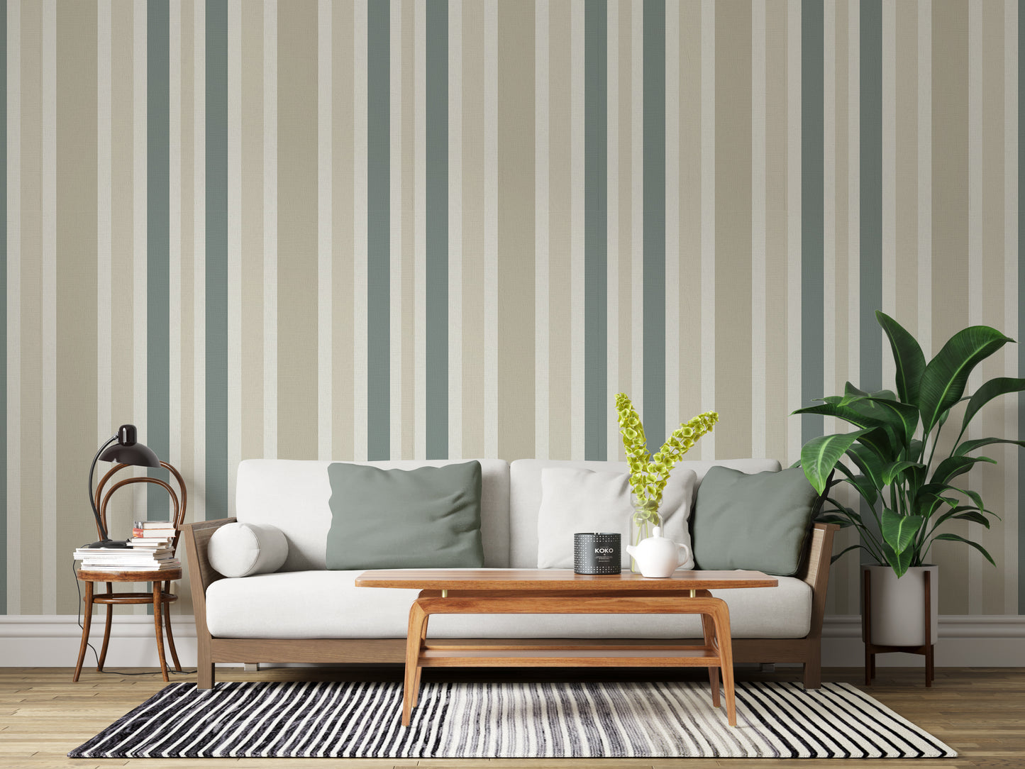 A minimal living room features a textured striped wallpaper in a whisper sand theme.
The fabric-textured design shows clean vertical lines in muted sage green, beige, and cream.
In front, a comfortable white sofa with grey throw pillows is centered in the space.
The calm interior setup is beautifully completed by a leafy green potted plant on the right.