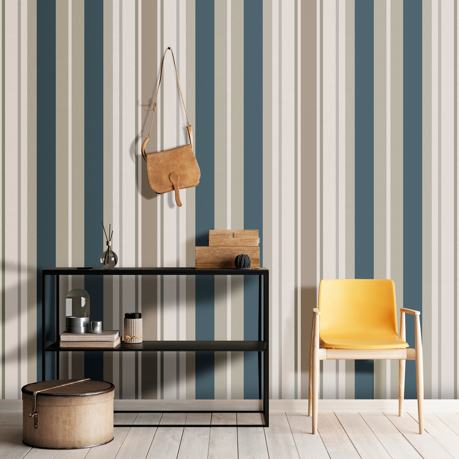 A modern room setup features a bold striped wallpaper in a sagewood theme.
The fabric-textured design shows alternating thick vertical bands of teal blue, warm beige, and soft cream.
In front, a vibrant yellow accent chair with light wood legs stands on the right side.
The contemporary interior setting is completed by a minimalist black metal shelving unit on the left.