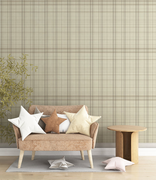 A modern bedroom features a textured plaid wallpaper in sahara blush and cream tones.
The fabric-look design displays a detailed grid pattern with intersecting soft pink, orange, and tan lines.
In front, a fully dressed bed with cream linens sits next to a classic pink wingback accent chair.
The elegant, cozy space is completed by a small wooden nightstand and a soft pink area rug.