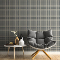A classic interior study space features a traditional plaid wallpaper in sage green and cream tones.
The detailed textile-look design showcases an intricate grid pattern of intersecting dark green and beige lines.
In front, a large dark wood desk with three drawers is paired with a comfortable taupe office chair.
The elegant, professional setting is completed by a warm desk lamp and a vibrant green potted plant.
