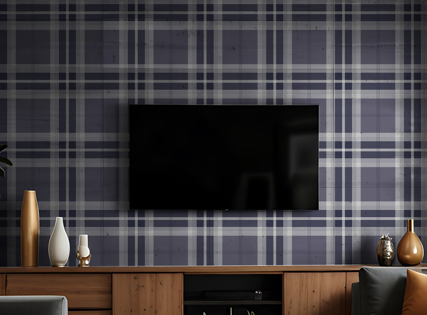 A modern living room features a classic plaid wallpaper in deep charcoal and light grey tones.
The detailed fabric-look design showcases an intricate grid pattern of intersecting lines across the wall.
In front, a unique dark grey tufted accent chair with angled wooden legs is positioned to the right.
The stylish setup is completed by a round white side table holding minimalist vases and decorative items.